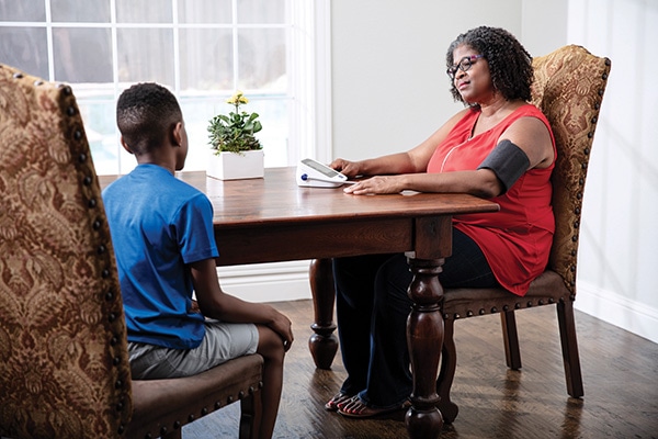 A caregiver measuring blood pressure at a table